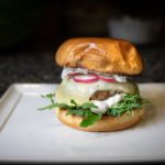 4 juicy Greek Burgers on a brioche bun with melted cheese and tzatiki sauce