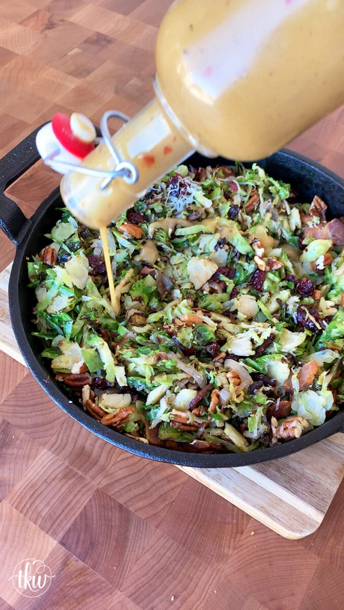 Our favorite holiday and summer salad! Shaved Brussels sprouts & shallots grilled in bacon drippings mixed with toasted pecans, and cranberries then drizzled with a maple dijon vinaigrette. Ultimate Grilled Brussels Sprouts Salad With Bacon Pecans and Cranberries, big green egg salad, maple dijon vinaigrette, grilled salad, warm salad, thanskgiving side dish, christmas side dish, summer salad, bacon and brussels sprouts salad