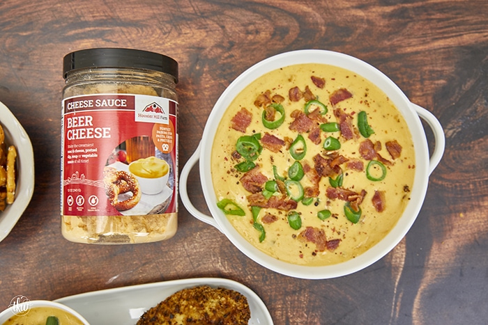 This loaded cheesy dip starts with the Hoosier Hill Beer Cheese Mix, more beer, shredded cheddar & smoked Gouda, crispy bacon, and minced jalapenos! This dip comes together in minutes! Ultimate Loaded Beer Bacon Jalapeno Cheese Dip, beer cheese, hot beer cheese dip, pretzel dip, football food, cheesy dip, beer dip