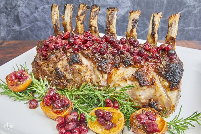 Make your holidays more spectacular with this mustard-glazed spiced rack of pork with cranberries, orange, and fresh rosemary slow-roasted to perfection. Ultimate Roasted Orange Cranberry Rosemary Rack of Pork, holiday pork, christmas dinner, roasted pork, roasted rack of pork, crown of pork