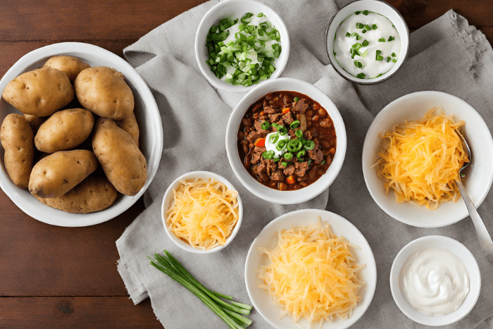 Perfectly baked potatoes fluffed up and stuffed with chili (bean or beanless), topped with 2 types of cheese, sour cream, and chives for the perfect anytime meal! Ultimate Loaded Chili Stuffed Baked Potatoes, chili baked potatoes, baked potatoes with chili, ways to use chili, ways to use up baked potatoes, baked potato bar, easy dinners, loaded baked potatoes