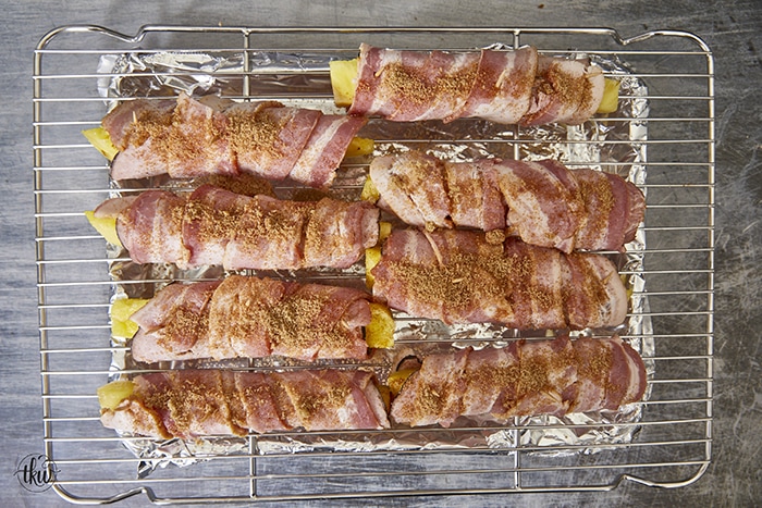 Get ready for a mouthwatering culinary adventure with a sweet and savory twist. Imagine crispy bacon, candied ham, juicy pineapple that's baked to perfection and finished with a decadent buttery maple bourbon glaze!Ultimate Buttery Maple Bourbon Glazed Candied Bacon Pineapple Spears, bacon wrapped pineapple, yoder smokers pizza oven, maple bourbon butter sauce, candied ham, summer cookout recipes, cookout appetizers, grilled pineapple