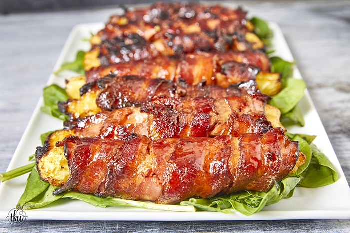 Get ready for a mouthwatering culinary adventure with a sweet and savory twist. Imagine crispy bacon, candied ham, juicy pineapple that's baked to perfection and finished with a decadent buttery maple bourbon glaze!Ultimate Buttery Maple Bourbon Glazed Candied Bacon Pineapple Spears, bacon wrapped pineapple, yoder smokers pizza oven, maple bourbon butter sauce, candied ham, summer cookout recipes, cookout appetizers, grilled pineapple