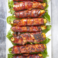 Get ready for a mouthwatering culinary adventure with a sweet and savory twist. Imagine crispy bacon, candied ham, juicy pineapple that's baked to perfection and finished with a decadent buttery maple bourbon glaze!Ultimate Buttery Maple Bourbon Glazed Candied Bacon Pineapple Spears, bacon wrapped pineapple, yoder smokers pizza oven, maple bourbon butter sauce, candied ham, summer cookout recipes, cookout appetizers, grilled pineapple