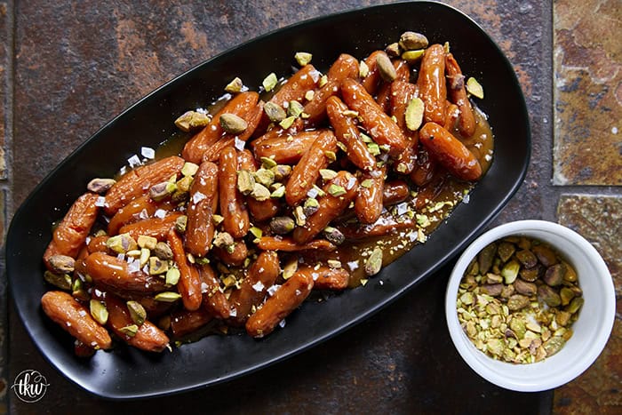 Turn ordinary carrots into something unforgettable! Roasted in a buttery, spiced maple sauce, then topped with toasted pistachios and a kiss of sea salt flakes, this side dish is guaranteed to steal the spotlight at any meal!