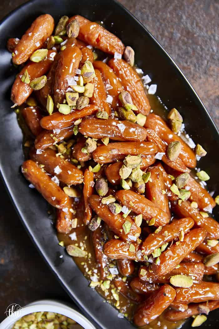 Turn ordinary carrots into something unforgettable! Roasted in a buttery, spiced maple sauce, then topped with toasted pistachios and a kiss of sea salt flakes, this side dish is guaranteed to steal the spotlight at any meal!