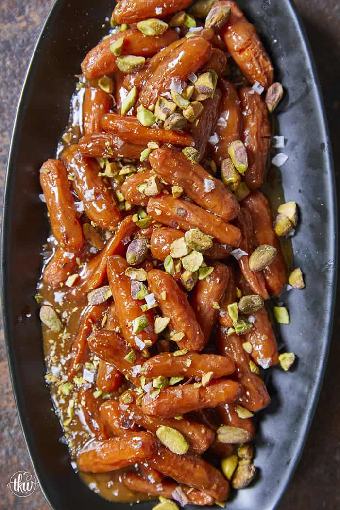 Turn ordinary carrots into something unforgettable! Roasted in a buttery, spiced maple sauce, then topped with toasted pistachios and a kiss of sea salt flakes, this side dish is guaranteed to steal the spotlight at any meal!