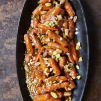 Turn ordinary carrots into something unforgettable! Roasted in a buttery, spiced maple sauce, then topped with toasted pistachios and a kiss of sea salt flakes, this side dish is guaranteed to steal the spotlight at any meal!