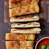 These cheese-stuffed breadsticks are the perfect blend of warm pizza dough, savory garlic butter, and gooey mozzarella for an irresistible bite! Made with simple pantry ingredients, they come together quickly for a delicious snack or the perfect side to any pizza or pasta night.