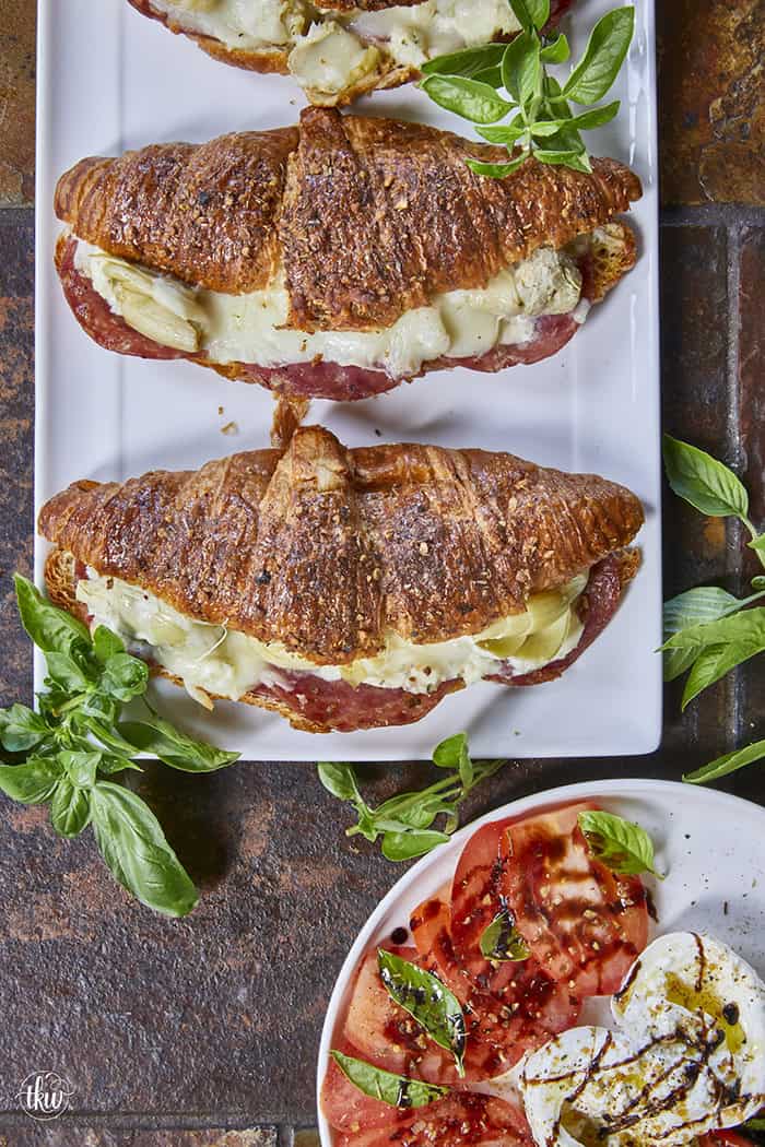 Buttery, flaky croissants stuffed with garlic butter spread, Boursin cheese, Italian meats, artichoke hearts, and mozzarella cheese. Topped with tomato slices, fresh basil, and a drizzle of balsamic glaze, they bake up perfectly golden, freeze beautifully, and are an easy Italian-inspired meal anytime!