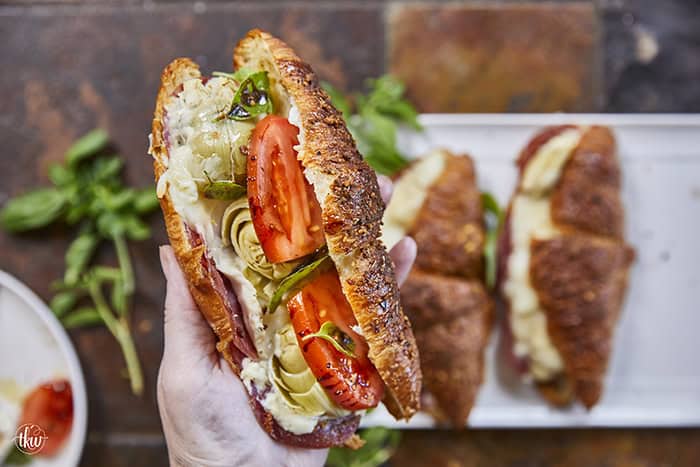 Buttery, flaky croissants stuffed with garlic butter spread, Boursin cheese, Italian meats, artichoke hearts, and mozzarella cheese. Topped with tomato slices, fresh basil, and a drizzle of balsamic glaze, they bake up perfectly golden, freeze beautifully, and are an easy Italian-inspired meal anytime!