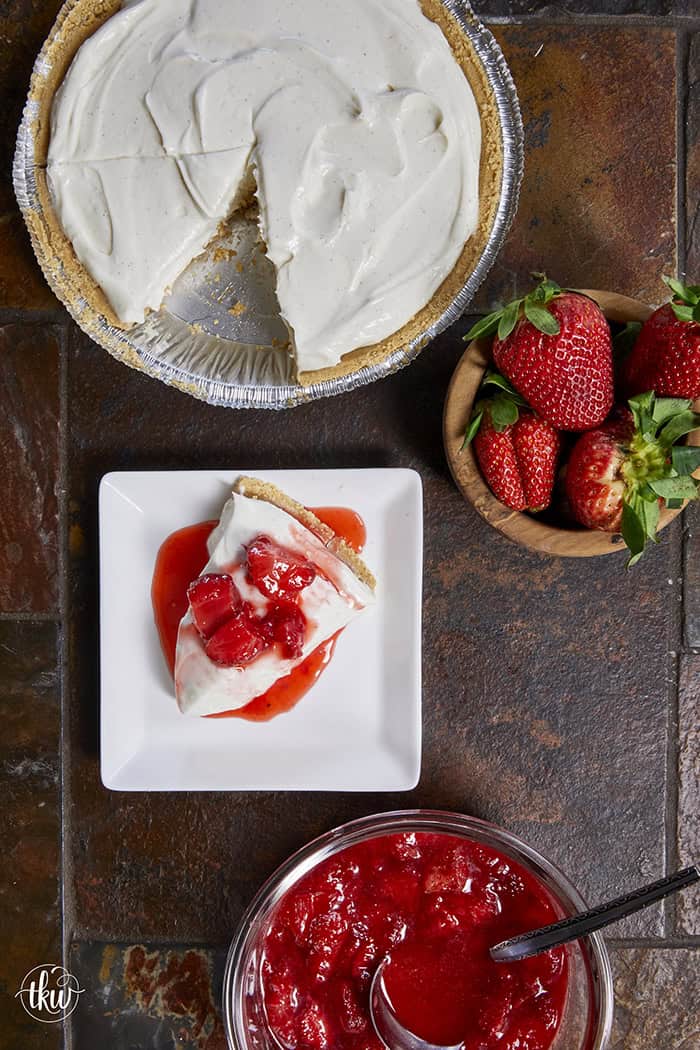 A creamy No-Bake Italian Ricotta Cheesecake on a serving stand, topped with fresh berries and showing elegant vanilla bean flecks.