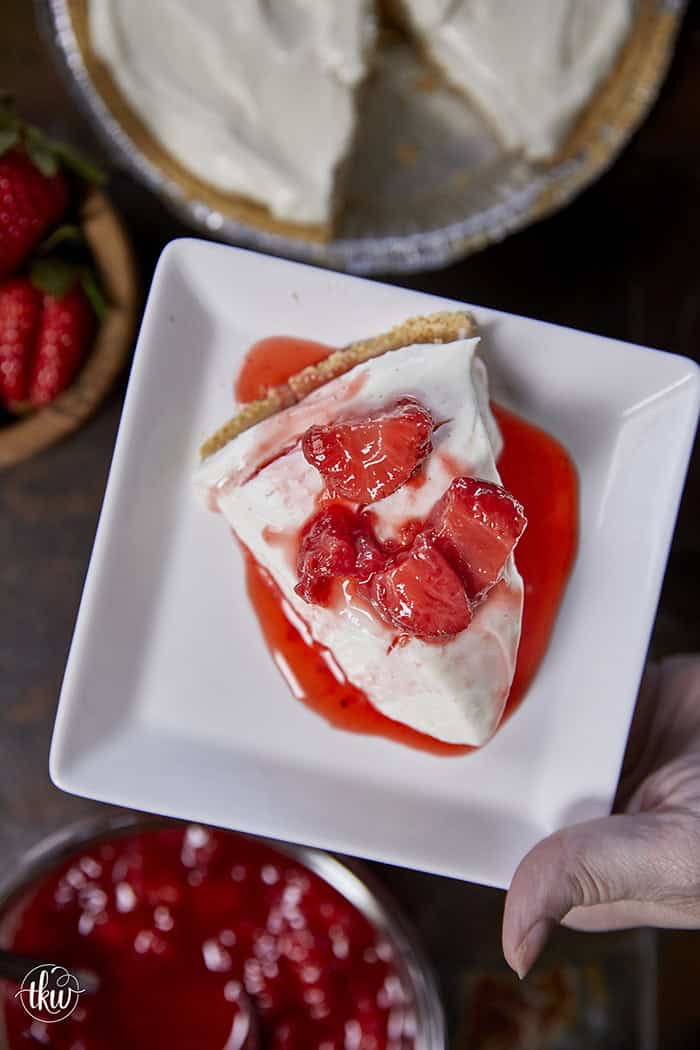 A close-up slice of silky, no-bake ricotta cheesecake on a plate, highlighting the light, velvety texture and real vanilla bean seeds.