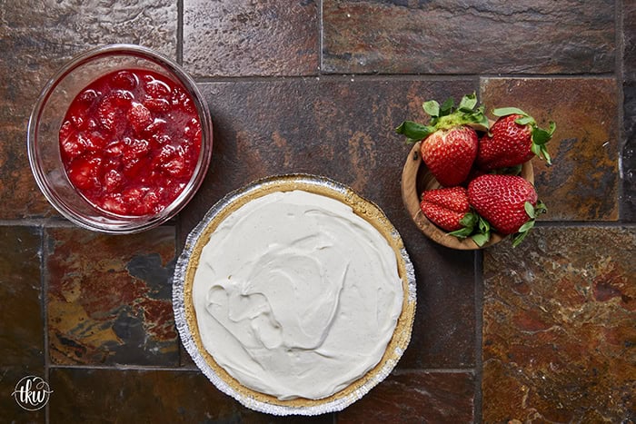 A creamy No-Bake Italian Ricotta Cheesecake, a bowl of fresh berries and showing elegant vanilla bean flecks.