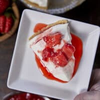 A close-up slice of silky, no-bake ricotta cheesecake on a plate, highlighting the light, velvety texture and real vanilla bean seeds.