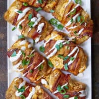This isn't just a snack—it's a full-blown sheet pan meal! These Loaded Bacon Wrapped Buffalo Chicken Hash Browns start with cripsy hash browns loaded with buffalo chicken and wrapped in smoky bacon. The ultimate comfort food dinner that's worth the wait! The ultimate meal prep dinner for game day or busy weeknights. #SheetPanMeals #BuffaloChicken #BaconWrapped #Hashbrowns #EasyDinner