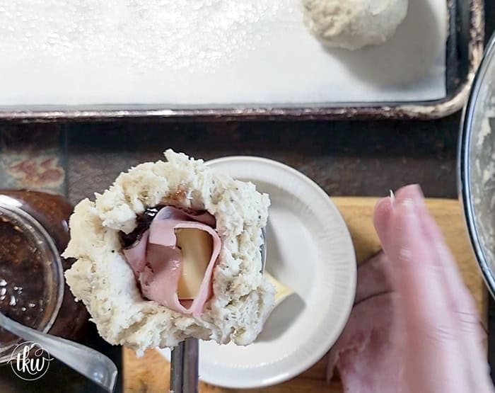 Taking my family's classic buttermilk drop biscuit recipe and give it a sophisticated, savory upgrade with savory ham, melted brie, fig jam, and black pepper. Perfect any time of the day, meal prep, and freeze meals. #ButtermilkBiscuits #BrunchRecipes #SavoryBaking #ComfortFood #stuffedbiscuits #hamandcheesebiscuits