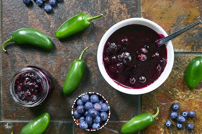 This easy Blueberry Jalapeño Jam recipe uses white balsamic and fresh berries for a flavor bomb that's perfect on burgers, pork, and smoked cream cheese. Whether you're a canning pro or just want a quick refrigerator jam, this simple recipe is a game changer for your next BBQ or charcuterie board! #BlueberryJalapenoJam #SweetHeat #CanningRecipes #HomemadeJam #SummerPreserves #AppetizerRecipes #SmokedCreamCheese #JalapenoBlueberry