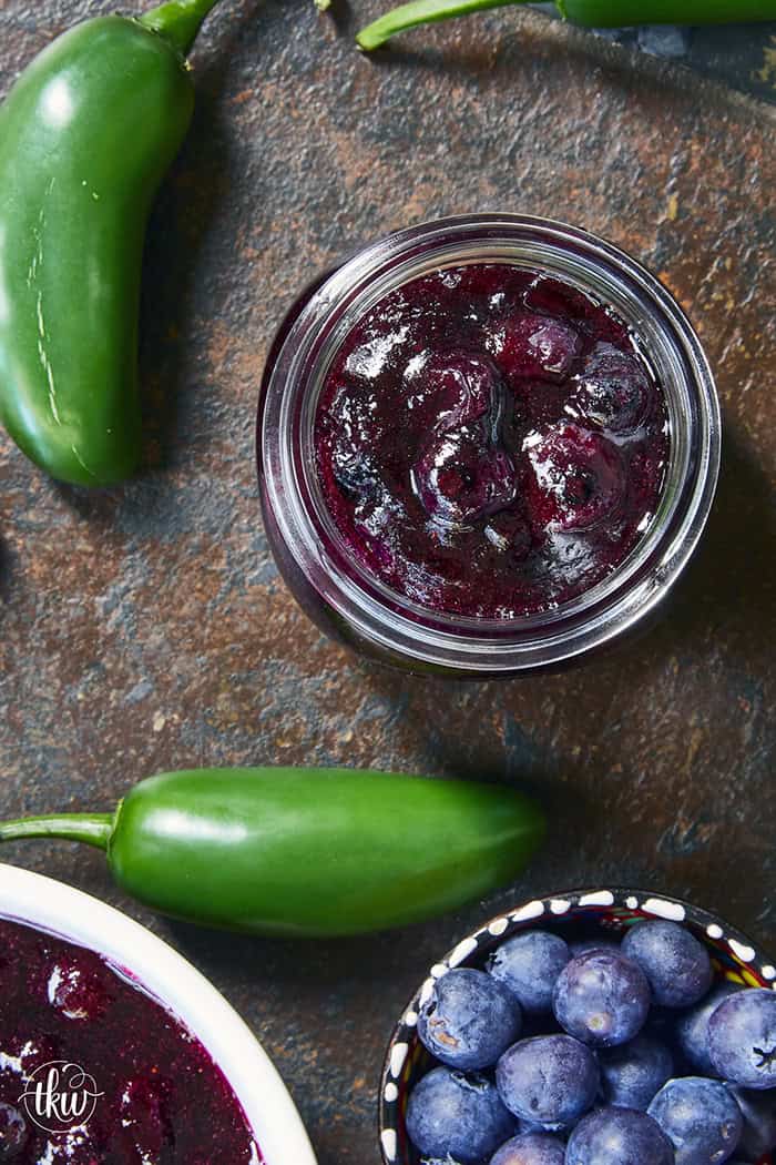 This easy Blueberry Jalapeño Jam recipe uses white balsamic and fresh berries for a flavor bomb that's perfect on burgers, pork, and smoked cream cheese. Whether you're a canning pro or just want a quick refrigerator jam, this simple recipe is a game changer for your next BBQ or charcuterie board! #BlueberryJalapenoJam #SweetHeat #CanningRecipes #HomemadeJam #SummerPreserves #AppetizerRecipes #SmokedCreamCheese #JalapenoBlueberry
