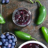 This easy Blueberry Jalapeño Jam recipe uses white balsamic and fresh berries for a flavor bomb that's perfect on burgers, pork, and smoked cream cheese. Whether you're a canning pro or just want a quick refrigerator jam, this simple recipe is a game changer for your next BBQ or charcuterie board! #BlueberryJalapenoJam #SweetHeat #CanningRecipes #HomemadeJam #SummerPreserves #AppetizerRecipes #SmokedCreamCheese #JalapenoBlueberry
