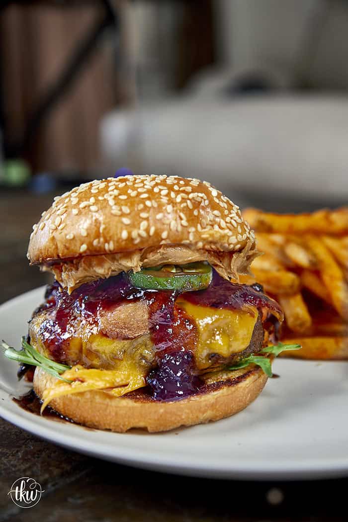 This Blueberry Jalapeño PB&J Bacon Cheeseburger is the best burger of the summer! Smoked ground brisket, melted cheddar, crispy bacon, and a sweet heat kick of blueberry jalapeño balsamic jam. #PBJBurger #BurgerRecipes #GrillingSeason