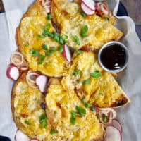 These Crispy Frico-Crusted BBQ Pulled Pork Sheet Pan Quesadillas are the dinner hack you need! Loaded with smoky pulled pork, tangy BBQ sauce, zesty green chiles, and a melty blend of two cheeses, they’re baked until a golden cheese frico crust forms. Whether you use the oven, air fryer, or grill, these are the perfect way to use up leftovers! #SheetPanDinner #Quesadillas #WeeknightDinner #LeftoverRecipes #GameDayFood #AirFryerRecipes #FricoCrust