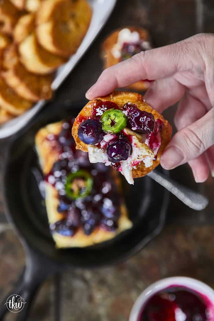 Looking for a killer appetizer? Try this Smoked Cream Cheese with Blueberry and Jalapeno Jam! A block of cream cheese gets a rich, wood-fired smoky flavor, then gets topped with a sweet-heat berry jam. It takes under 10 minutes of hands-on prep, and I'll show you how to make it in a smoker, grill, or kitchen oven. It is the perfect dip for party crackers, a spread for bagels, or a burger topper! #SmokedCreamCheese #SmokerRecipes #EasyAppetizers