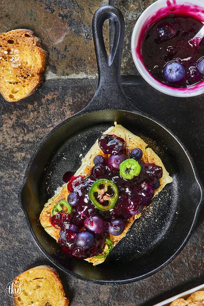 Looking for a killer appetizer? Try this Smoked Cream Cheese with Blueberry and Jalapeno Jam! A block of cream cheese gets a rich, wood-fired smoky flavor, then gets topped with a sweet-heat berry jam. It takes under 10 minutes of hands-on prep, and I'll show you how to make it in a smoker, grill, or kitchen oven. It is the perfect dip for party crackers, a spread for bagels, or a burger topper! #SmokedCreamCheese #SmokerRecipes #EasyAppetizers