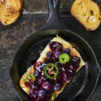 Looking for a killer appetizer? Try this Smoked Cream Cheese with Blueberry and Jalapeno Jam! A block of cream cheese gets a rich, wood-fired smoky flavor, then gets topped with a sweet-heat berry jam. It takes under 10 minutes of hands-on prep, and I'll show you how to make it in a smoker, grill, or kitchen oven. It is the perfect dip for party crackers, a spread for bagels, or a burger topper! #SmokedCreamCheese #SmokerRecipes #EasyAppetizers