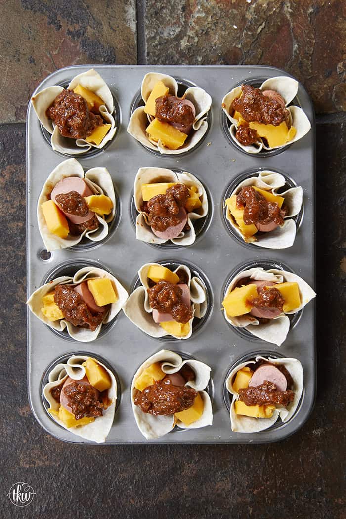 Looking for the best game day appetizer? These Crispy Chili Dog Wonton Cups are a total crowd-pleaser! 🌭🧀 Made with simple ingredients like bean-free chili, chopped hot dogs, and plenty of melted cheese, they are the perfect crunchy, bite-sized snack for your next cookout or movie night. A great way to use up leftover hot dogs in just 20 minutes! #ChiliDogWontonCups #GameDayEats #EasyAppetizers #WontonRecipes