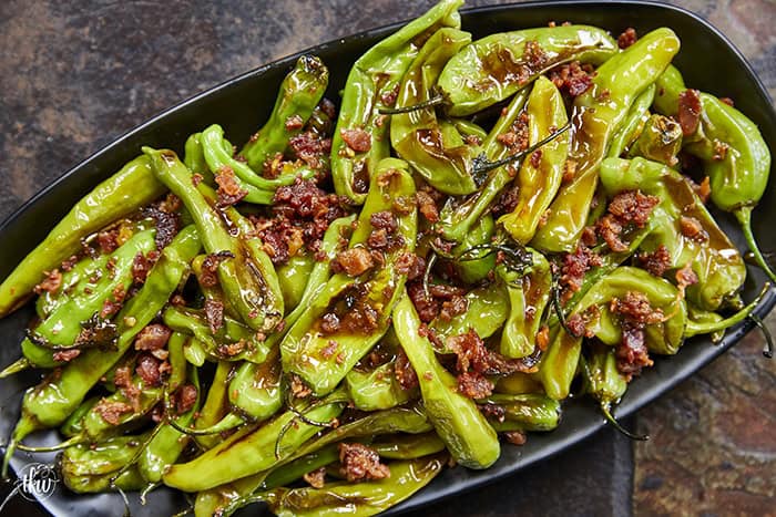 Blistered to perfection and tossed in a sticky, homemade garlic-honey glaze, these shishito peppers hit every single craving. Top them with crispy bacon crumbles for a 15-minute, sweet-and-smoky umami bomb. #ShishitoPeppers #honeygarlicsauce #fingerfoods