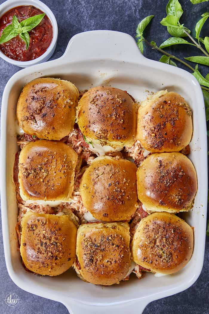 These golden brioche sliders are piled high with juicy shredded chicken tossed in rich marinara, layered with fresh basil and thick, melty mozzarella, and finished with a savory Italian-seasoned butter glaze. All the flavors of classic chicken parmesan, but without the knife and fork! #ChickenParmSliders #onepanDinner #PartyFood #PulledChicken #SliderRecipes