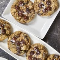 Turn fresh garden zucchini into the ultimate decadent dessert! These thick, chewy oatmeal zucchini chocolate chip cookies pack the perfect balance of hearty oats and gooey dark chocolate pockets, all with deep notes of brown sugar and molasses. Discover the dual-oat secret to keeping these bakery-style cookies perfectly chewy and never cakey. #zucchinicookies #oatmealchocolatechip #cookiesofpinterest
