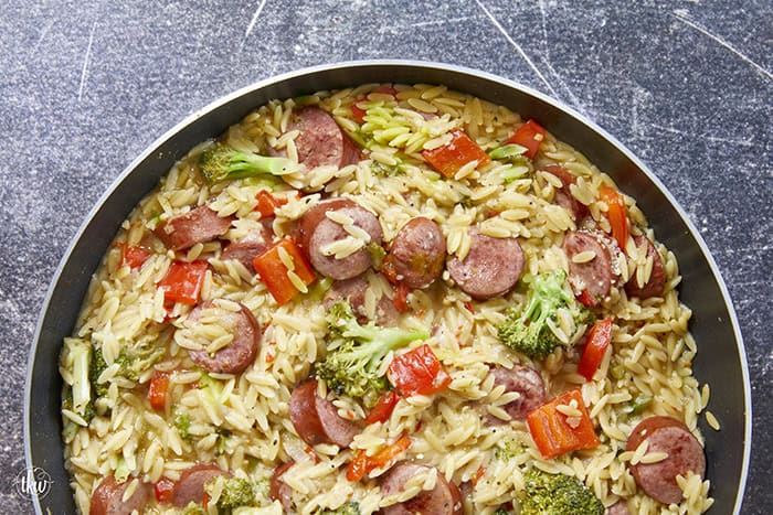20-minute weeknight dinner made in just ONE skillet! This Sausage Broccoli Orzo combines smoky kielbasa, tender broccoli, and a velvety Parmesan herb sauce—no heavy cream needed. Perfect for busy nights and meal prep! #thekitchenwhisperer #20minutemeals #onepanmeals