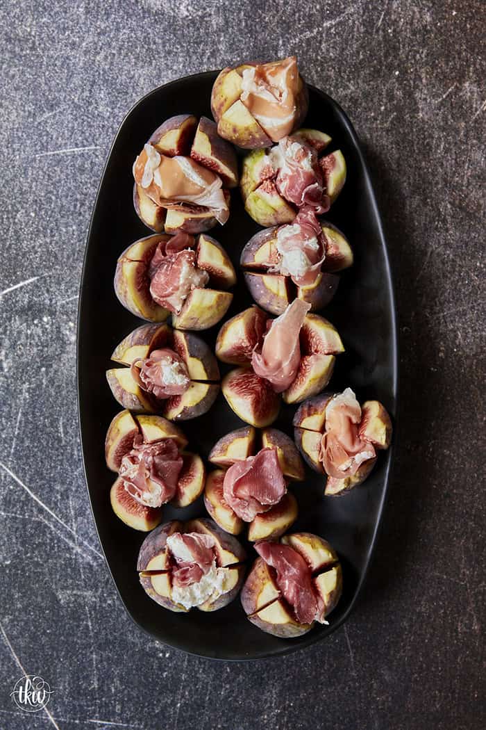 Elegant, easy, and ready in 15 minutes! Fresh figs are stuffed with fluffy whipped goat cheese, wrapped in savory prosciutto, and drizzled with balsamic glaze. Try this simple appetizer today!