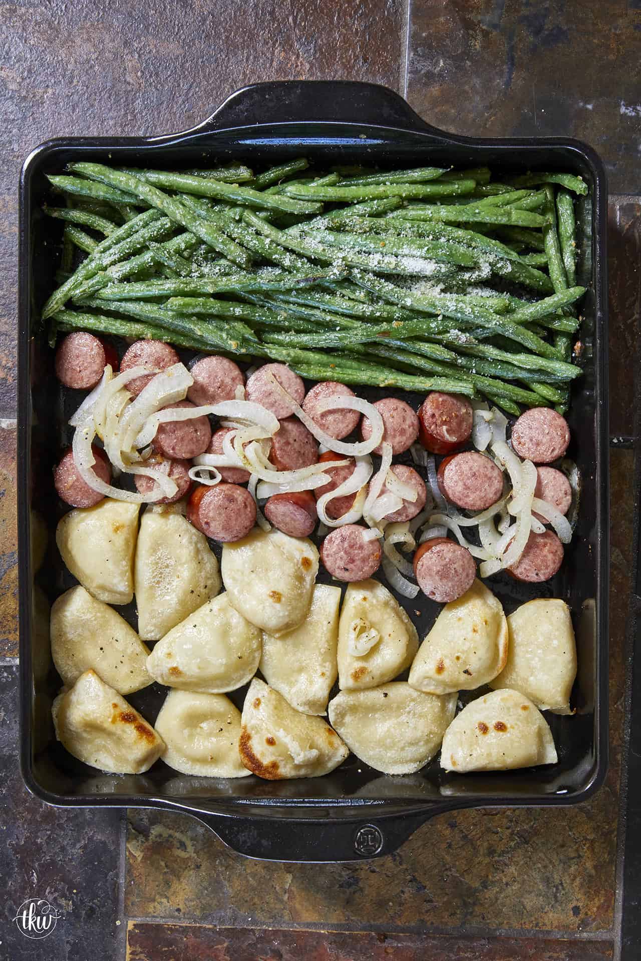 Need a quick 30-minute weeknight dinner? This easy sheet pan kielbasa and pierogies recipe combines smoked Polish sausage, caramelized onions, crispy fresh pierogies, and garlic Parmesan green beans all on one pan. Perfect for easy family dinners and meal prep!