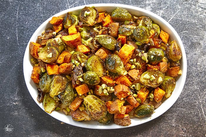 Sheet-pan roasted Brussels sprouts and sweet potatoes tossed in a warm spiced maple glaze and toasted pistachios. An easy side dish that is naturally vegan, gluten-free, and perfect for any dinner table.