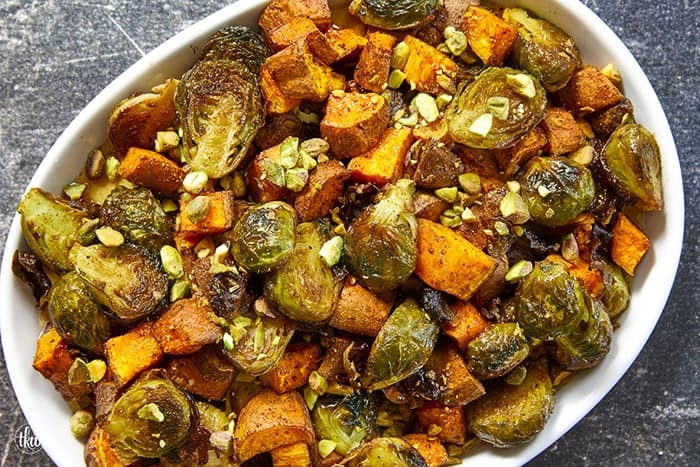 Sheet-pan roasted Brussels sprouts and sweet potatoes tossed in a warm spiced maple glaze and toasted pistachios. An easy side dish that is naturally vegan, gluten-free, and perfect for any dinner table.