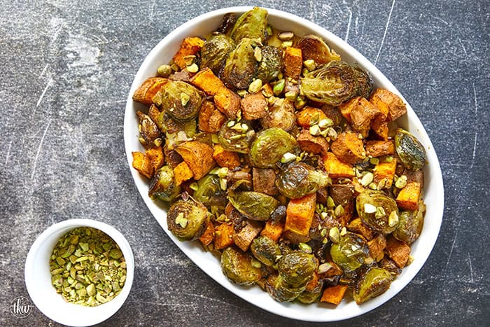 Sheet-pan roasted Brussels sprouts and sweet potatoes tossed in a warm spiced maple glaze and toasted pistachios. An easy side dish that is naturally vegan, gluten-free, and perfect for any dinner table.